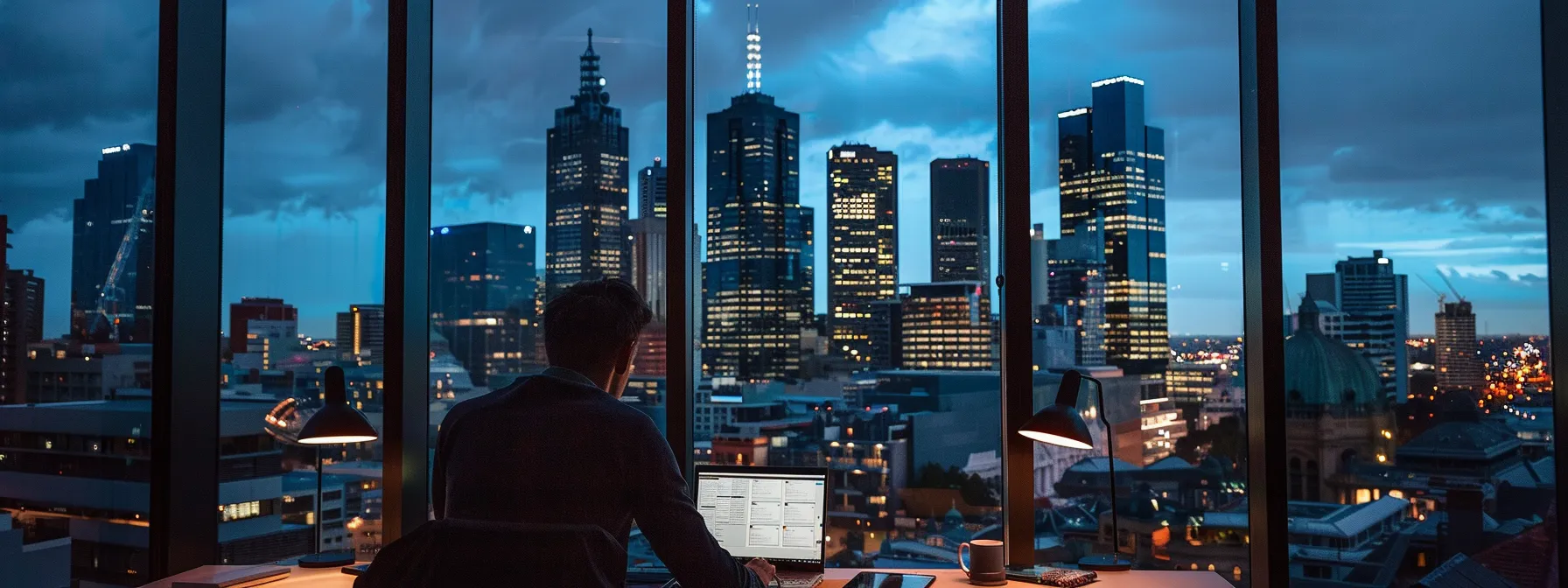 a person sitting at a laptop surrounded by melbourne city skyline in the background, working on building high-quality local links for their online authority.