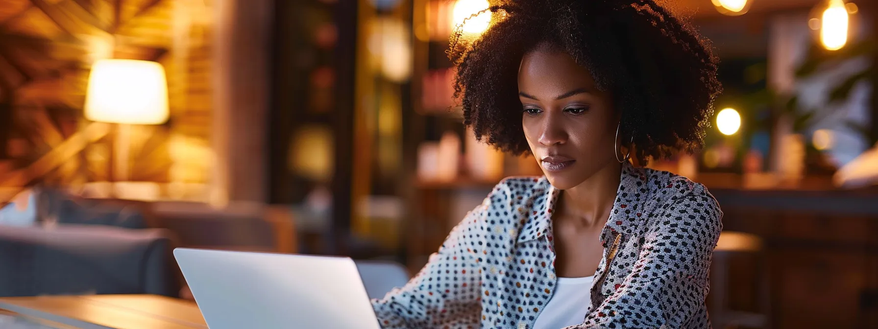 a woman working on a laptop, creating personalized email content for her cosmetology business.