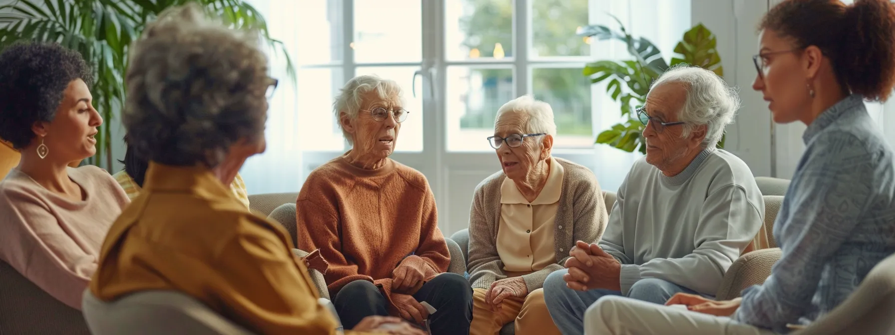 a group of elderly patients and their families engaged in a digital strategy meeting with geriatric health professionals.