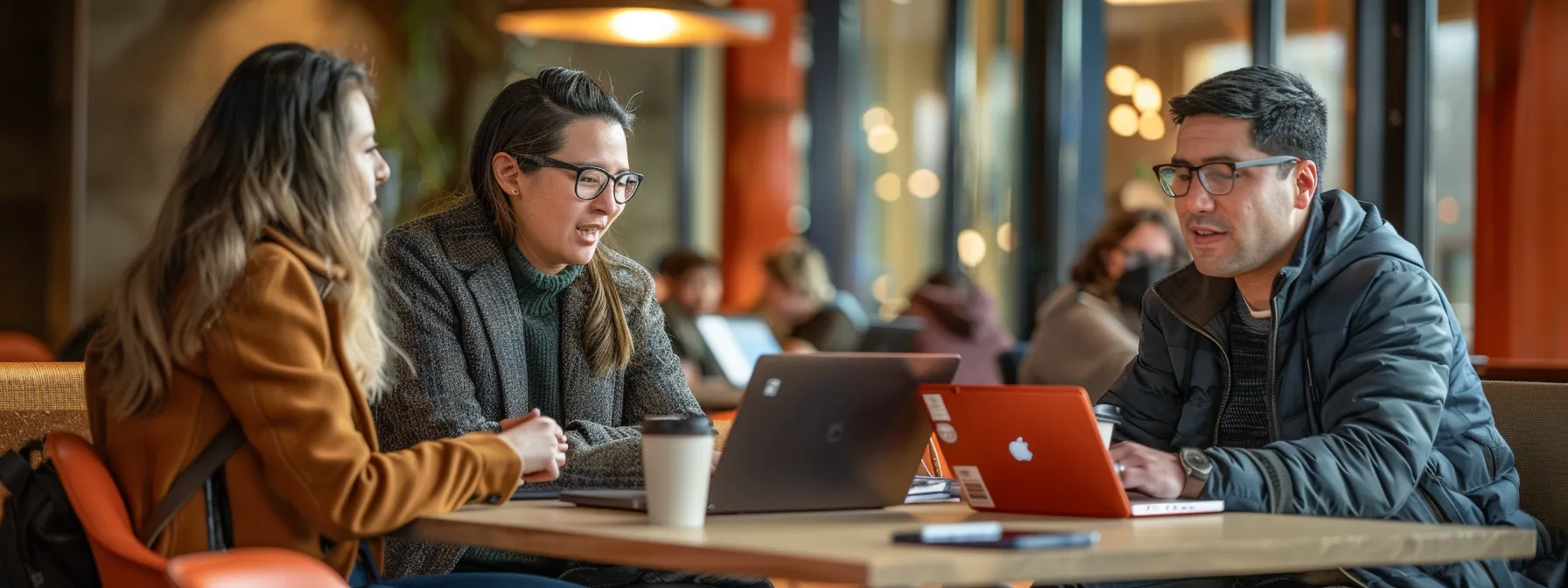 a group of marketing professionals discussing strategies with laptops and coffee cups in hand.