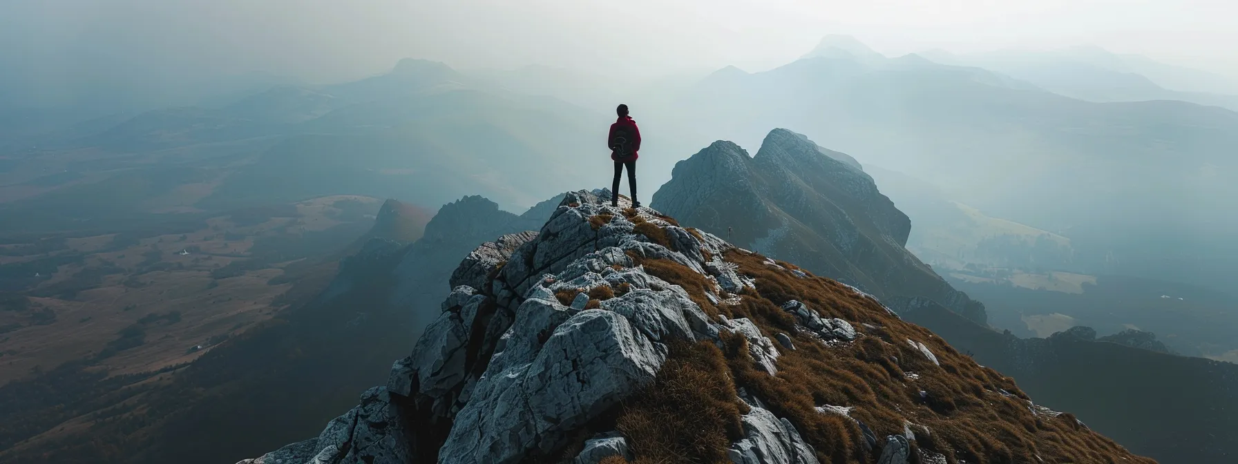 a person standing at the summit of a mountain, enjoying the vast view of endless possibilities.