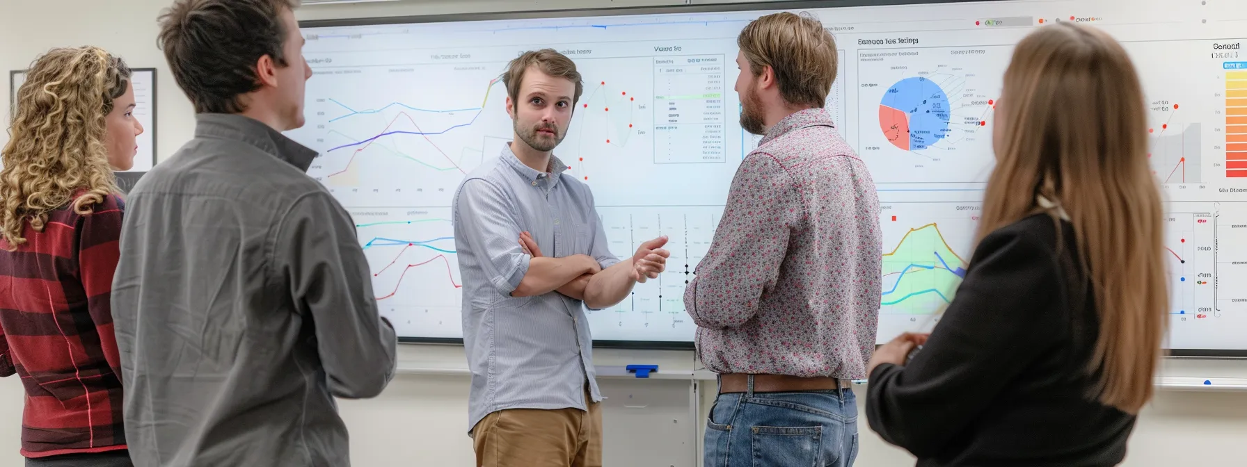 a group of people gathered around a whiteboard filled with graphs and charts, engaged in a discussion about measurement tools and techniques for unlocking success.